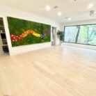 A large moss artwork with flowers in a modern space