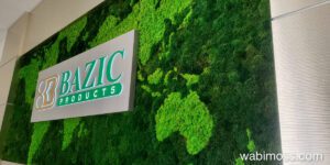 World map made our of moss with a company sign in the middle.