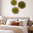 Set of three 12-inch preserved moss wood slice wall art pieces arranged above a neutral bedroom headboard on a white wall